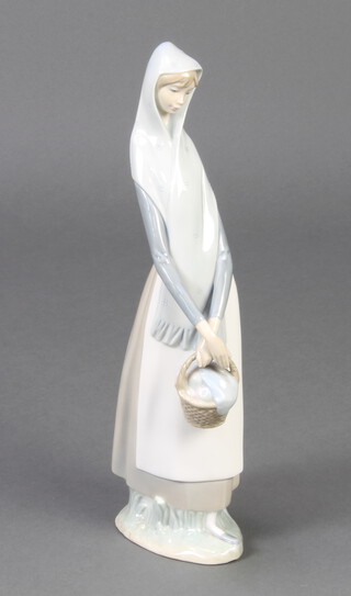 A Lladro figure of a standing lady with basket 23cm 