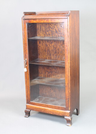 A 1930's oak display cabinet with 3/4 gallery, fitted shelves enclosed by a glazed panelled door, raised on bracket feet 136cm h x 62cm w x 33cm d 