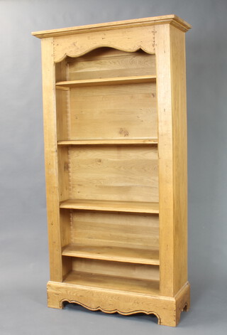 A Victorian style elm bookcase with moulded cornice and adjustable shelves, raised on bracket feet 201cm h x 105cm w x 39cm d 