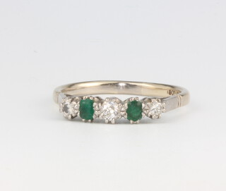 An 18ct white gold emerald and diamond ring, the 3 brilliant cut diamonds approx. 0.17ct, the 2 oval cut emeralds approx. 0.3ct, gross weight 4 grams, size T 