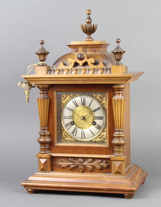 Hamburg American Clock Co., a 14 day striking on gong bracket clock with gilt dial and silvered chapter ring, contained in a carved walnut case 