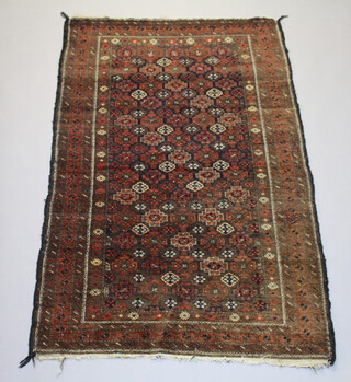 A brown and red ground belouche rug with all over floral design within a multi row border 176cm x 110cm 