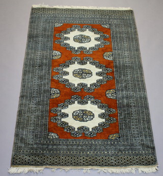 A brown, white and grey ground Bokhara rug with 3 stylised octagons to the centre within a multi row border 195cm x 122cm 