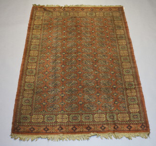 An orange ground machine made Bokhara style carpet with numerous octagons to the centre 230cm x 153cm 