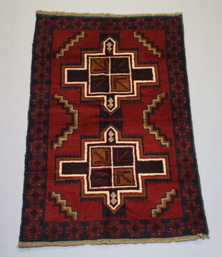 A brown, red and blue ground Baluchi rug with 2 stylised diamonds to the middle 136cm x 86cm 