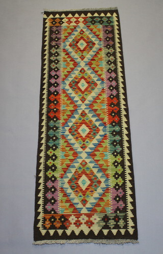 A yellow, brown and turquoise patterned Chobi Kilim runner with 4 stylised diamonds to the centre 192cm x 62cm 