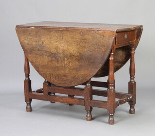 An 18th Century oak oval drop flap gateleg dining table fitted a frieze drawer raised on turned supports 72cm h x 96cm w x 40cm when closed x 129cm when open 
