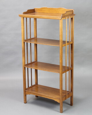 An oak Art Nouveau style 4 tier bookcase with 3/4 gallery, raised on square supports 128cm h x 63cm w x 32cm d 
