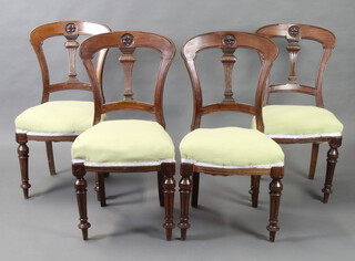 A set of 4 Victorian carved mahogany spoon back dining chairs with vase shaped slat backs and over stuffed seats, raised on turned supports 
 
