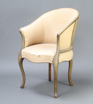 An Edwardian bleached mahogany show frame tub back chair upholstered in cream material on cabriole supports
