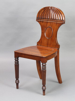 A Regency shaped mahogany hall chair with solid seat raised on turned and reeded supports 