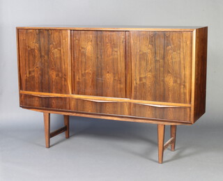 A mid-Century rosewood sideboard, the interior fitted shelves and 2 short drawers enclosed by panelled sliding doors, the base fitted 3 long drawers and raised on square tapered supports 112cm h x 165cm w x 43cm d.  Cites certificate reference No.594781/01