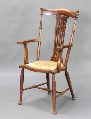An Edwardian Art Nouveau turned beech slat back open armchair raised on turned supports with yellow upholstered seat 
