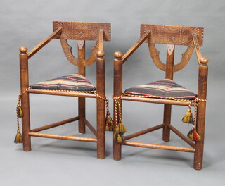 A pair of 19th Century carved oak Turners chairs with solid seats raised on turned supports 