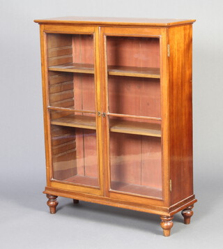 A Victorian mahogany bookcase, fitted shelves enclosed by glazed panelled doors, raised on bun feet 103cm h x 79cm w x 27cm d 