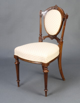 A Victorian carved walnut show frame chair with upholstered seat and back, raised on turned and fluted supports  