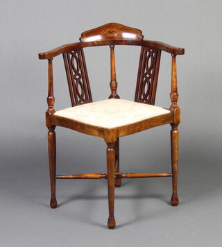 An Edwardian inlaid mahogany corner chair with pierced slats to the side, raised on turned supports with X framed stretcher 