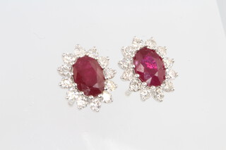 A pair of 18ct white gold oval ruby and diamond ear studs, rubies approx. 1.93ct, the brilliant cut diamonds 0.75ct, 11mm, 3.2 grams