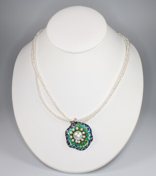 A silver necklace set with pearls and enamel on a pearl necklace 