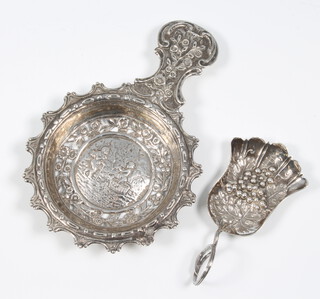 A George III repousse silver caddy spoon, the bowl decorated with grapes and vines, Birmingham 1810, maker Taylor and Perry together with a Continental pierced silver sifter spoon 55 grams 