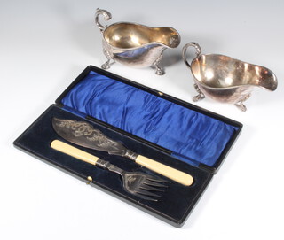 Two silver plated sauce boats and a pair of cased plated fish servers