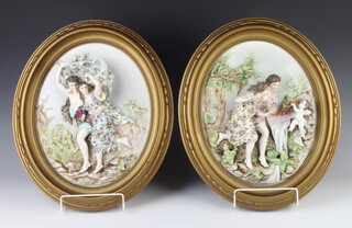 A pair of late 19th Century German porcelain oval plaques depicting figures in garden landscapes, framed, 32cm x 23cm 