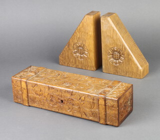 A 19th Century rectangular carved walnut glove box with hinged lid and strap decoration 8cm h x 30cm w x 9cm d together with Peter R Pearson a pair of wedge shaped carved oak bookends decorated Tudor roses 18cm h x 12cm x 5.5cm  