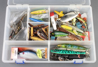 A collection of vintage and modern pike fishing lures contained within a plastic case  