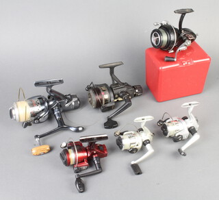 K P Morritts Intrepid Elite fishing reel contained in a black plastic case, a Power Carp reel, a Carbovan 900 RB fishing reel and pouch and 4 other reels 