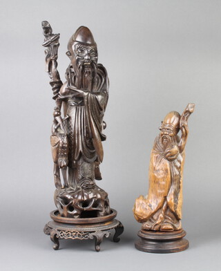 A 19th Century Japanese carved and inlaid hardwood figure of a standing deity with stork raised on a hardwood stand 44cm h x 13cm and 1 other hardwood figure of a deity on a hardwood stand 27cm x 9cm x 8cm  
