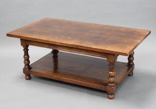 A rectangular oak 2 tier coffee table on turned and block supports 48cm h x 122cm l x 68cm w (light pitting to 1 side) 
