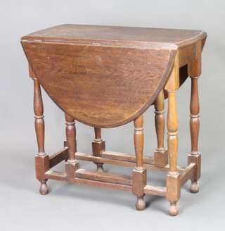 A 1930's oak oval drop flap gateleg tea table 72cm h x 73cm w x 35cm d 