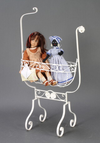 A Victorian style white painted metal swinging crib 109cm h x 56cm w x 28cm d containing a Zapf collectors doll with certificate and a felt doll 