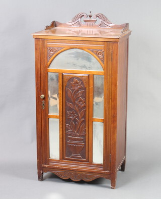 An Edwardian carved walnut sheet music cabinet with carved 3/4 gallery enclosed by a mirror panelled door, raised on turned supports 67cm h x 55cm w x 48cm d (contact and ring marks in places) 