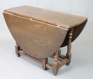 An oak oval drop flap gateleg dining table 75cm h x 113cm w x 45cm d 