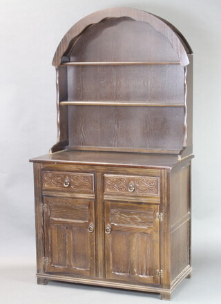 A carved oak dresser with arched back fitted 2 shelves, the base fitted 2 drawers above double cupboard 180cm h x 96cm w x 51cm d