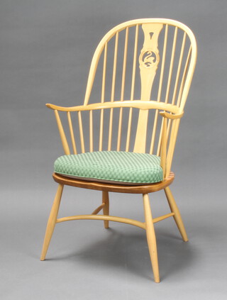 An Ercol light elm swan back Millenium chair with crinoline stretcher, the splat back with gold Ercol mark and 0607  