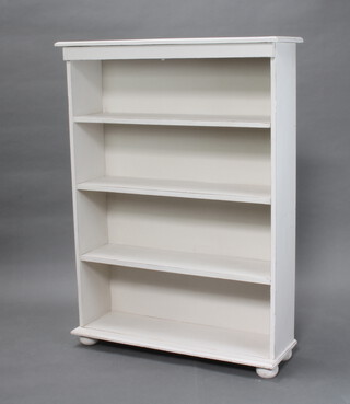 A white painted 4 tier bookcase on bun feet 127cm h x 94cm w x 27cm d 