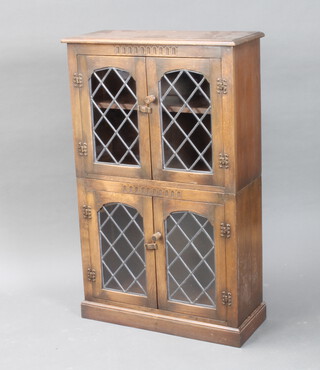 An oak bookcase enclosed by lead glazed panelled doors 110cm h x 70cm w x 29cm d (slight burn marks to the top) 