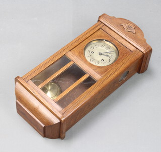 A 1930's chiming wall clock with silvered dial contained in an oak case 60cm h x 27cm w x 15cm d 