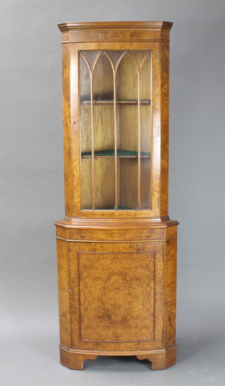 A Queen Anne style figured walnut double corner cabinet with moulded cornice, enclosed by astragal glazed panelled doors, the base enclosed by panelled doors, raised on bracket feet 182cm h x 46cm w 