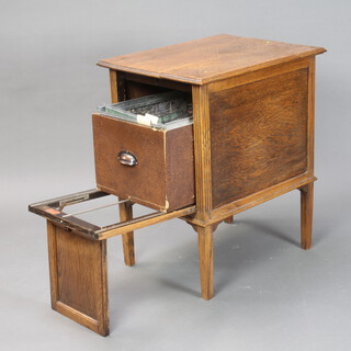 A 1920's light oak rectangular drop flap filing cabinet with fluted decoration, on square tapered supports 74cm h x 48cm w x 60cm d (split to the top) 