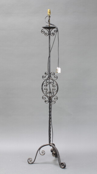 A wrought iron standard lamp raised on a triform base 152cm h x 41cm diam. 