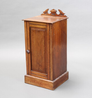 A Victorian walnut pot cupboard with carved raised back, enclosed by panelled doors on a platform base 76cm h x 36cm w x 32cm d (some scratches and water marks in places)
