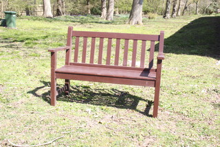 A brown painted wooden slatted garden bench 86cm h x 119cm w x 57cm d 
