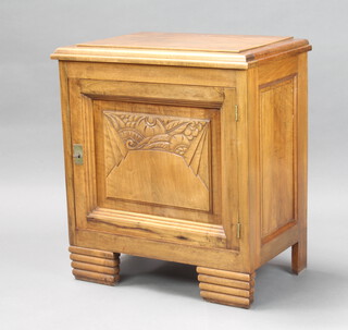 A Chinese style hardwood cabinet with hinged lid, base enclosed by a carved panelled door on square reeded supports 171cm h x 65cm w x 41cm d 