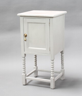 A light blue painted bedside cabinet enclosed by a panelled door on bobbin turned supports 76cm h x 41cm w x 37cm d 