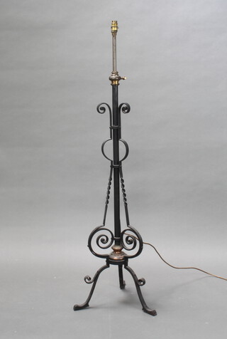 A Victorian brass and wrought iron adjustable standard oil lamp converted to electricity on a triform base 134cm h x 41cm diam. to base 