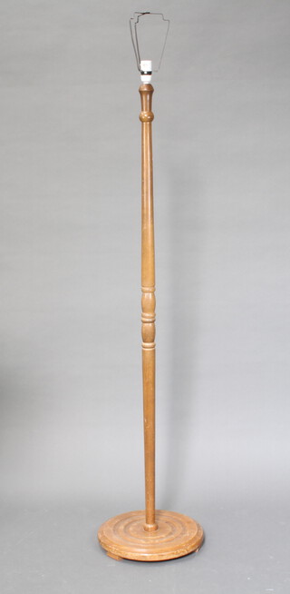 A 1960's turned beech standard lamp on a circular base 145cm h x 34cm diam (some water marks to base)