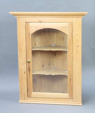 A pine hanging corner cupboard with moulded cornice, fitted shelves enclosed by arched panelled door 104cm h x 85cm w x 60cm d